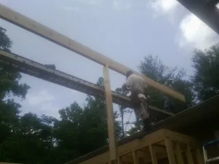 Carpenter setting a ridge beam over a new addition frame — Ice Dam Removal by Roofing Brothers in Orderville