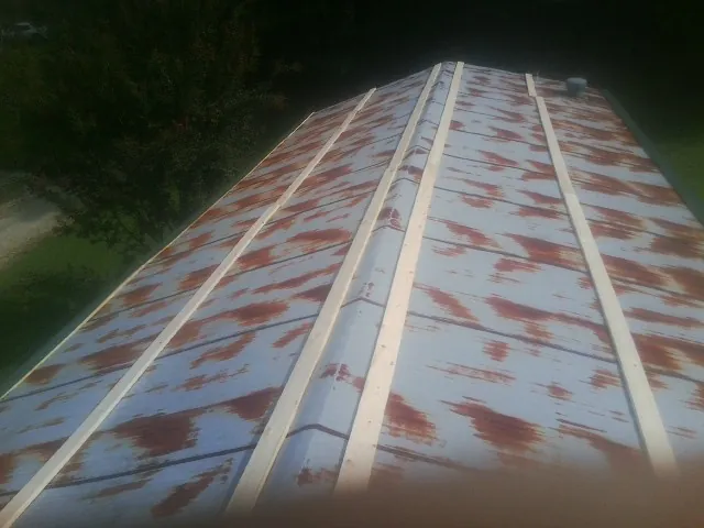 Rusted metal roof panels with new wood purlins before replacement — Storm Damage Roof Repair in Orderville by Roofing Brothers